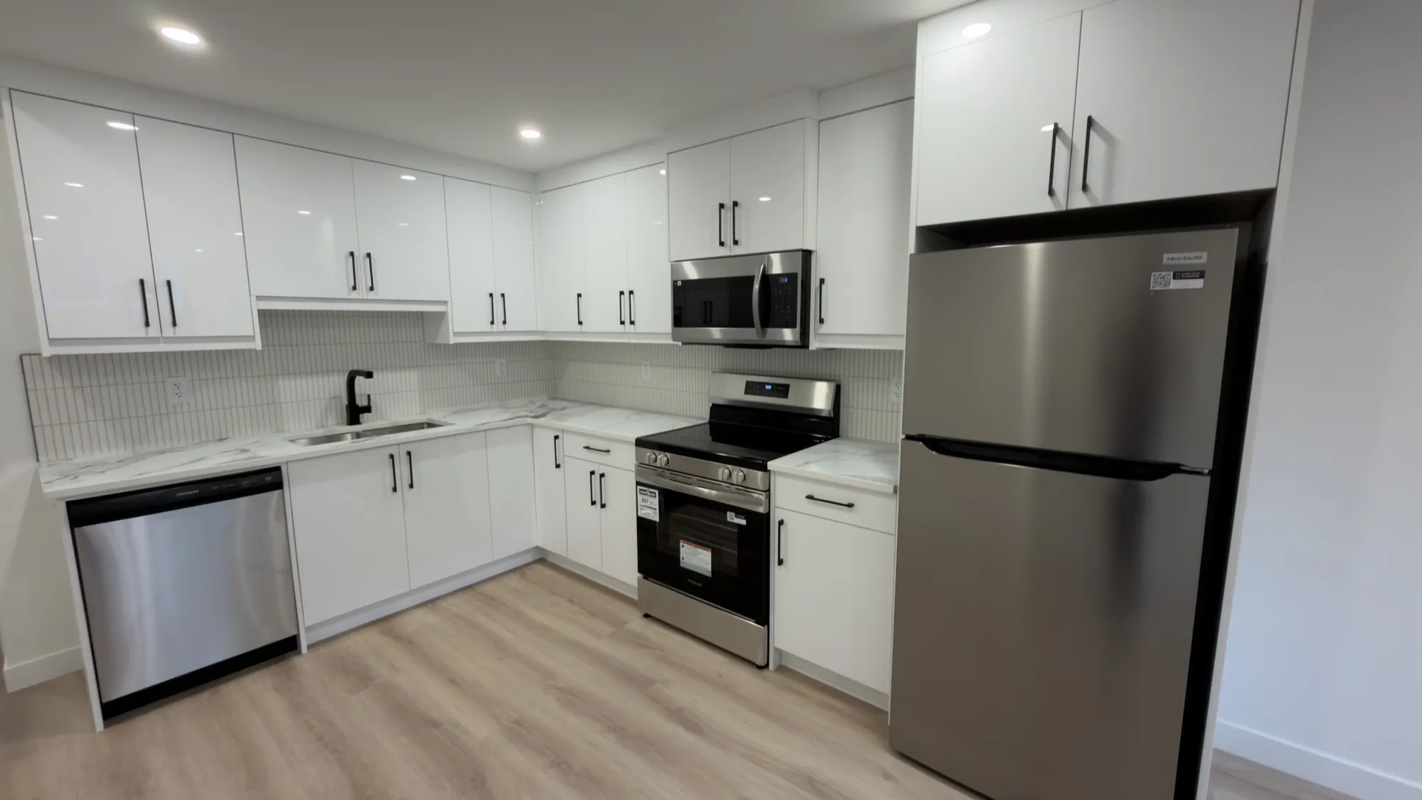 Basement suite kitchen, quartz counters and marble backsplash